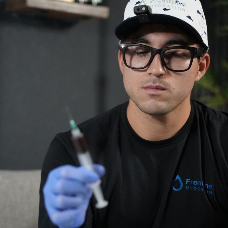 Gabriel Velastegui, founder of Frontline Hydration, preparing a wellness shot in the IV lounge