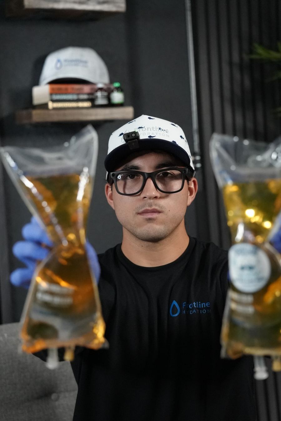 Gabe from Frontline Hydration holding two vitamin IV bags