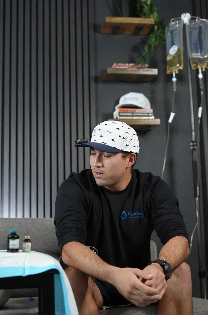 Frontline Hydration provider in the IV lounge with drips hanging in the background